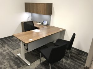 A desk and chairs in the available office space